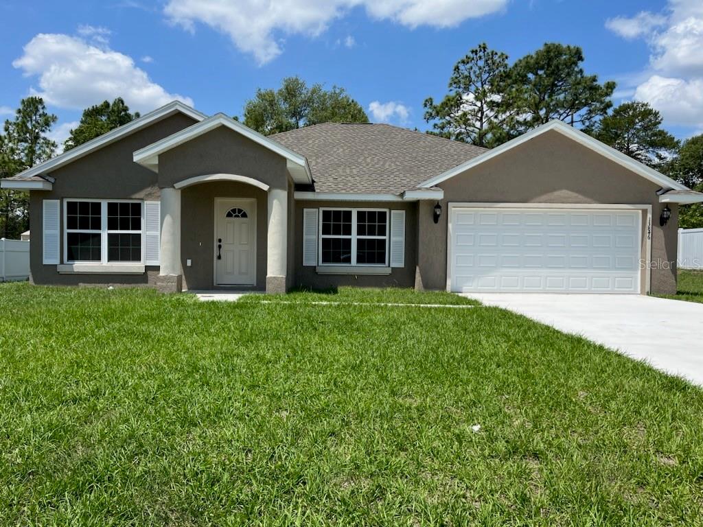 a front view of a house with yard and green space