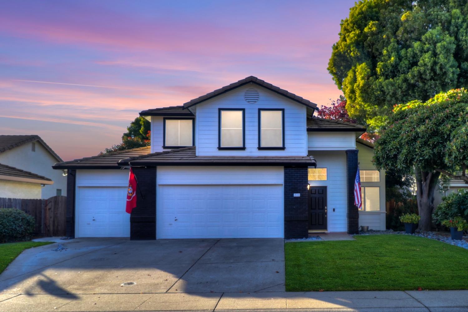 a front view of a house with a yard and garage