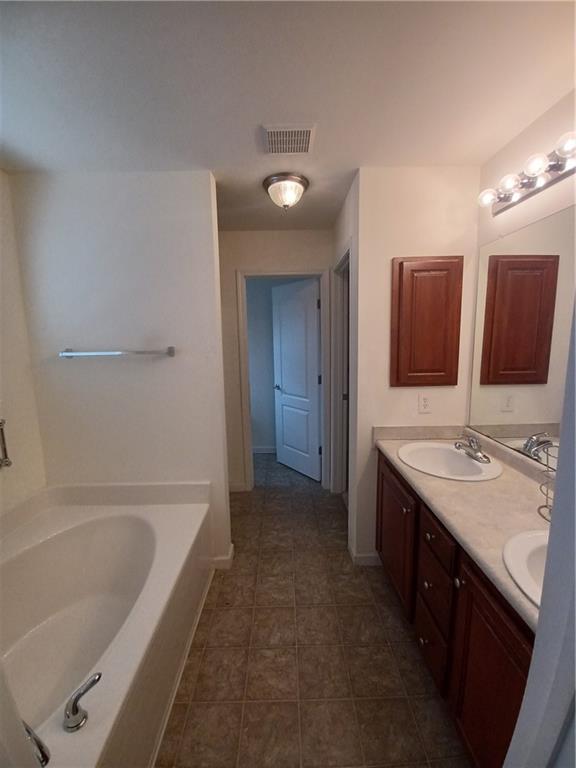 a bathroom with a tub sink and mirror