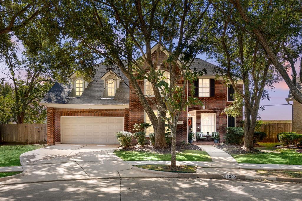 a view of a house with a tree in front of it