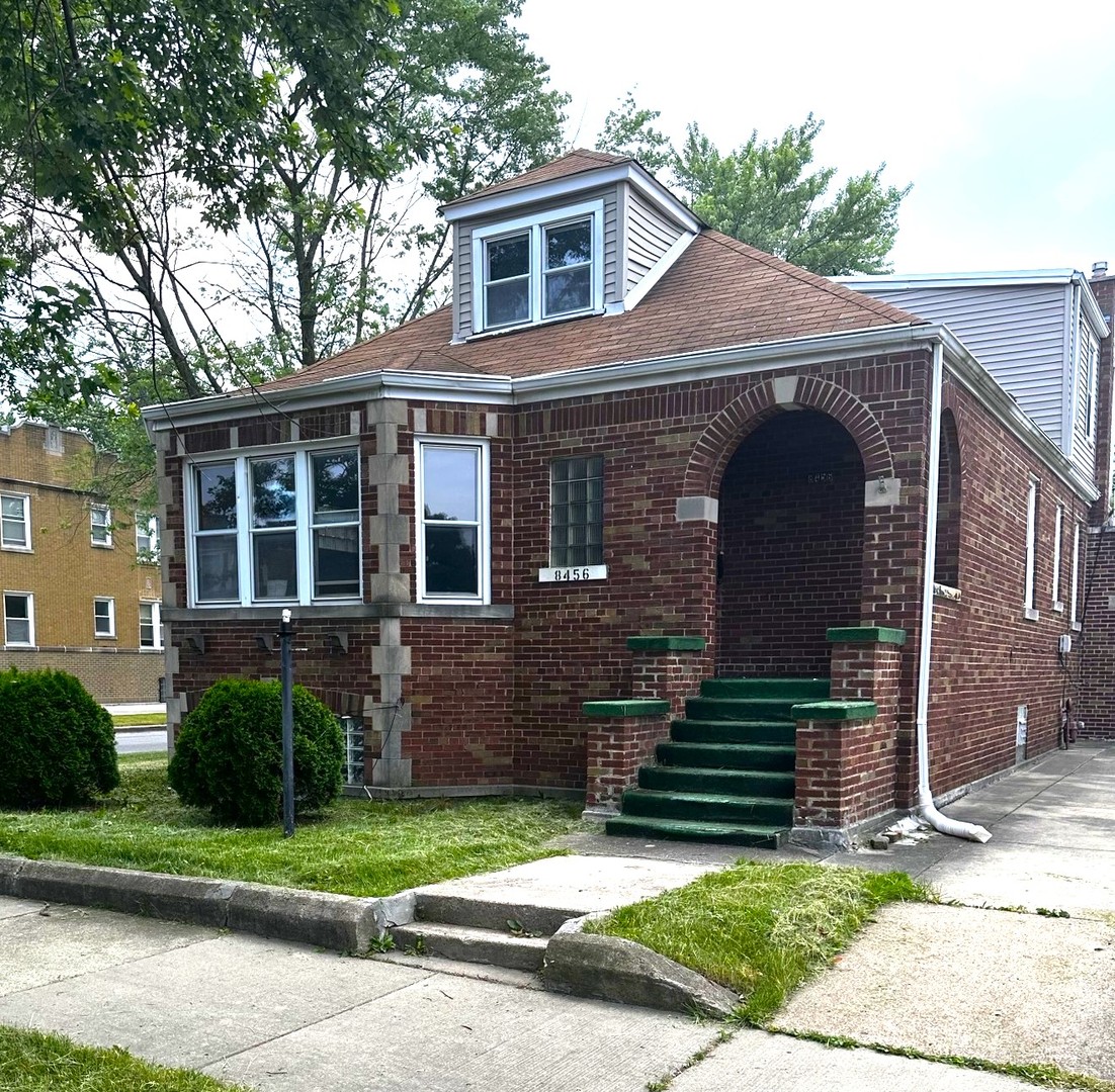 a front view of a house with a garden