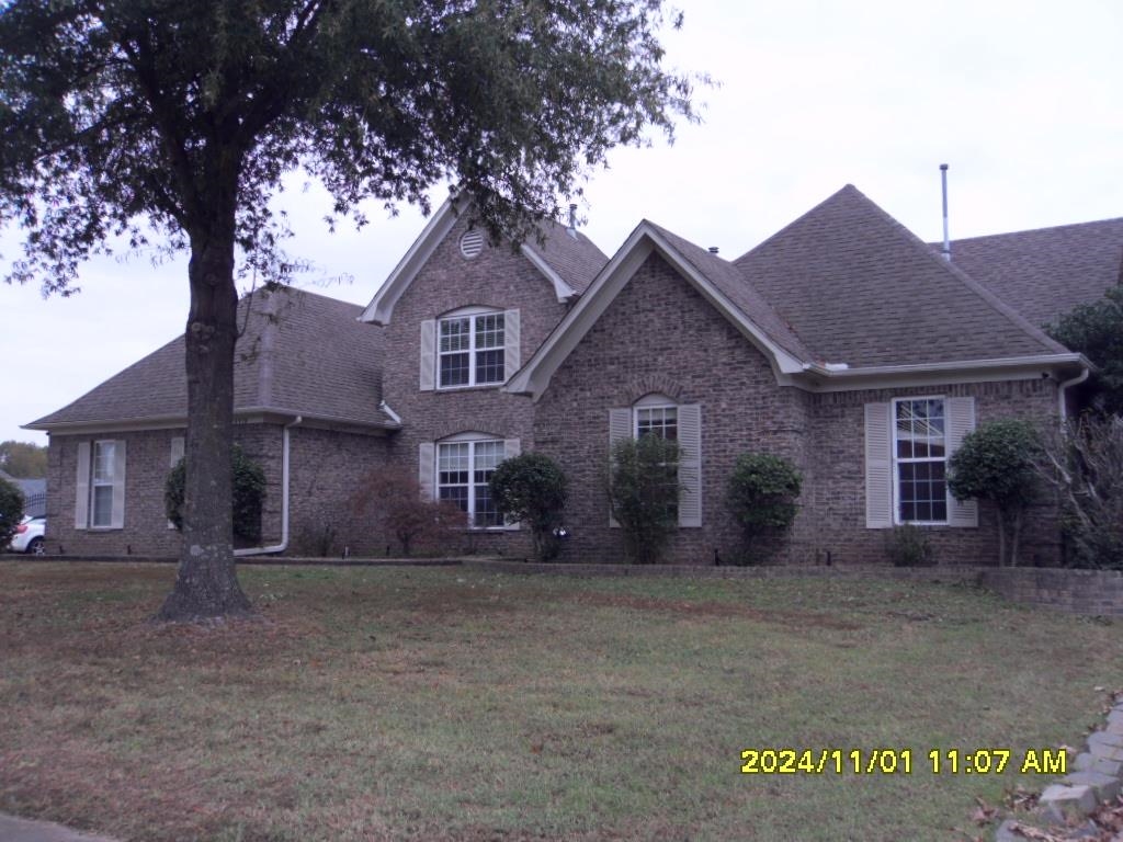 a front view of a house with a tree