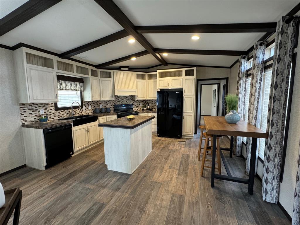 a kitchen with a table chairs refrigerator and cabinets