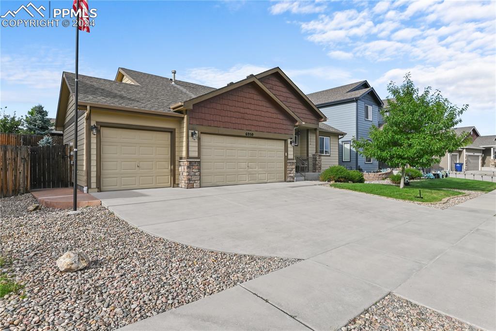 View of front of house featuring a front lawn and a garage