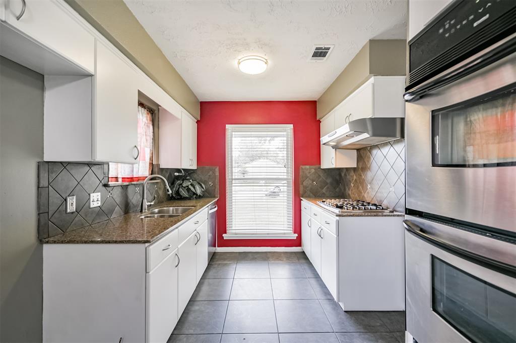 a kitchen with stainless steel appliances granite countertop a sink and a stove