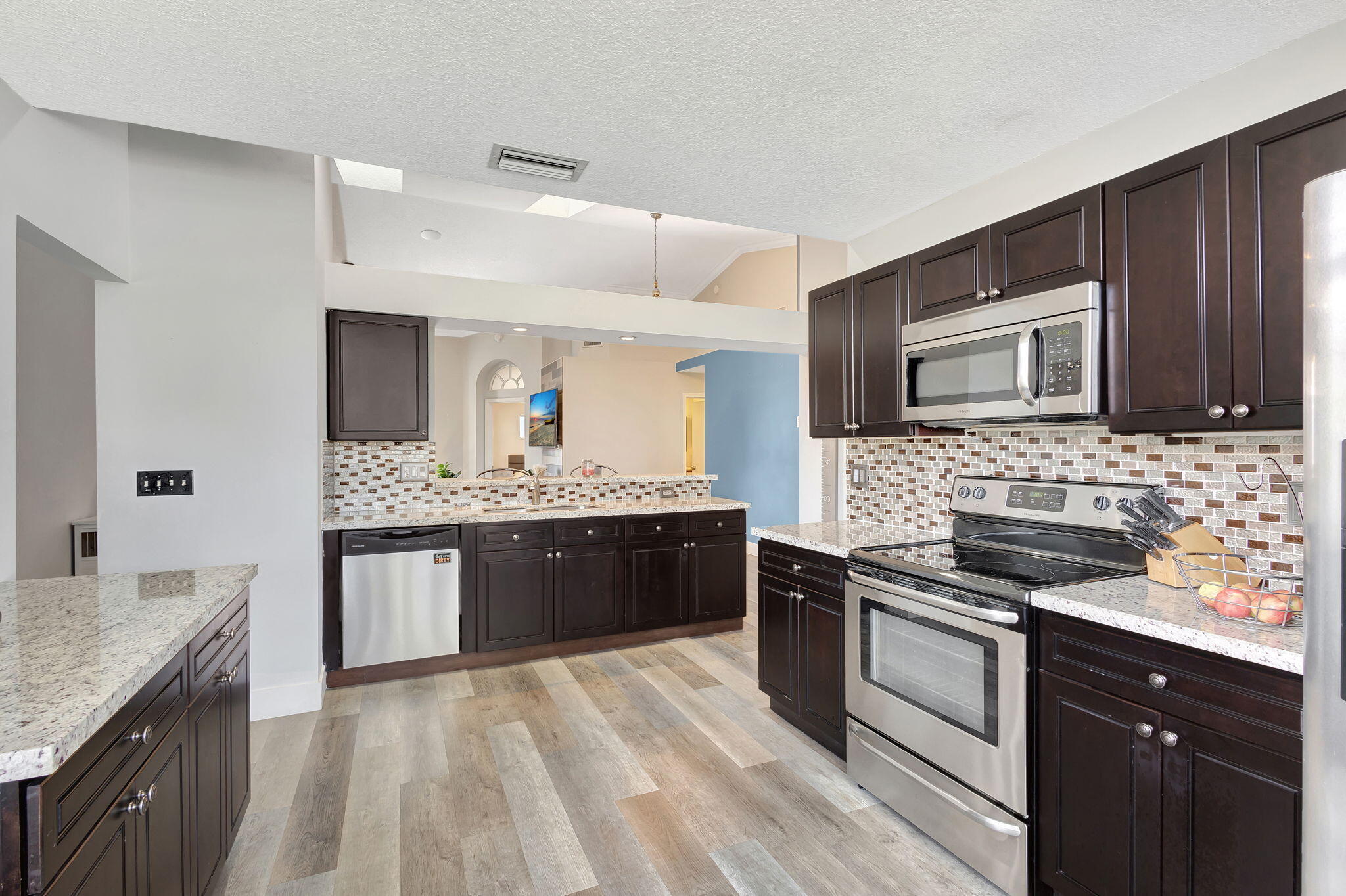 a large kitchen with granite countertop a sink and cabinets