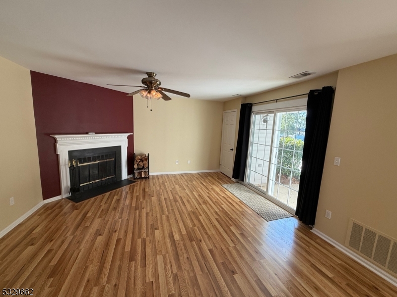 a view of an empty room with a fireplace and a window