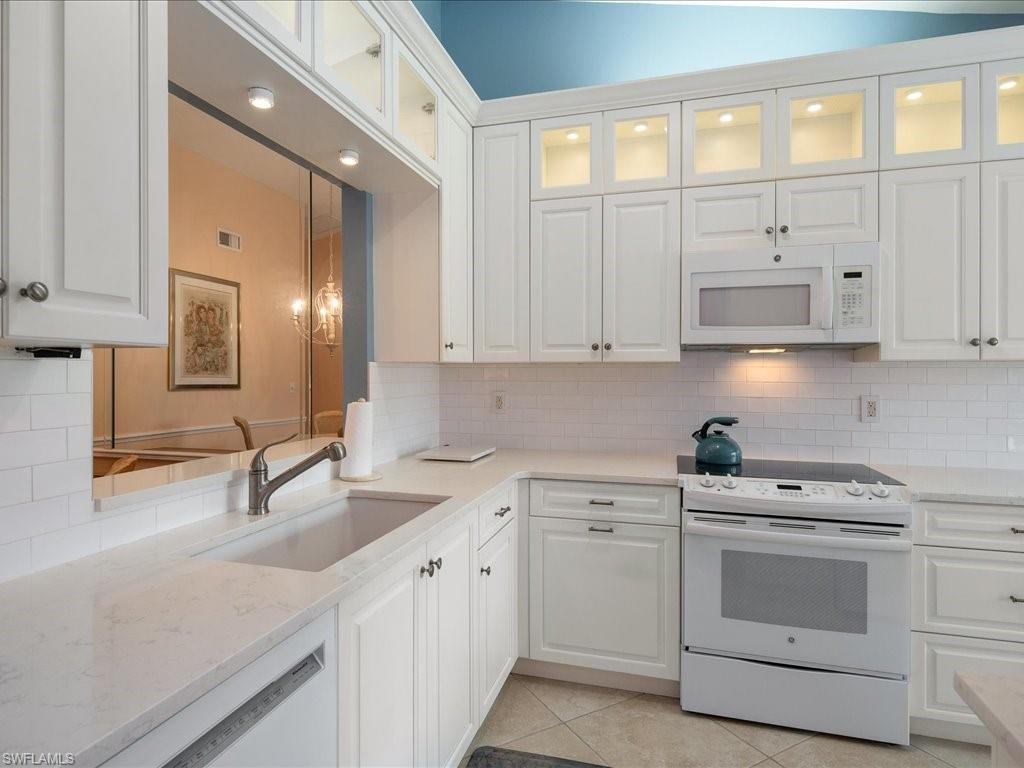 a kitchen with white cabinets and white appliances