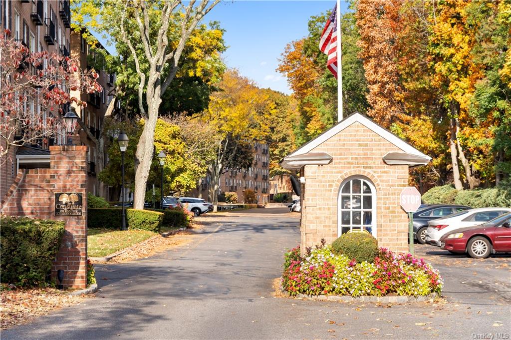 a view of a white house next to a road and a yard