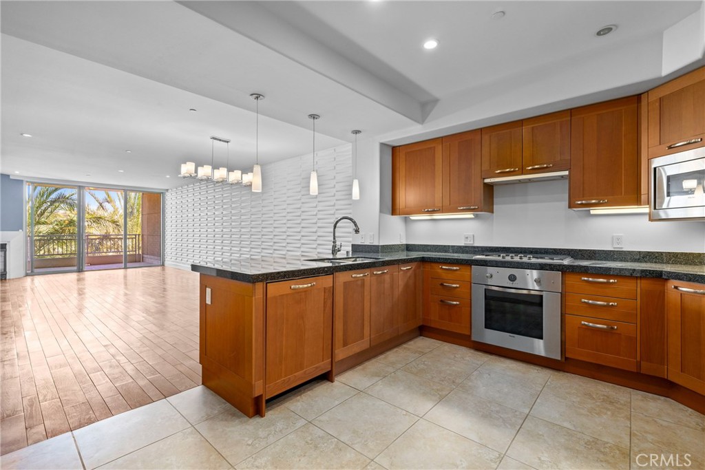 a large kitchen with stainless steel appliances granite countertop a stove a sink and a microwave