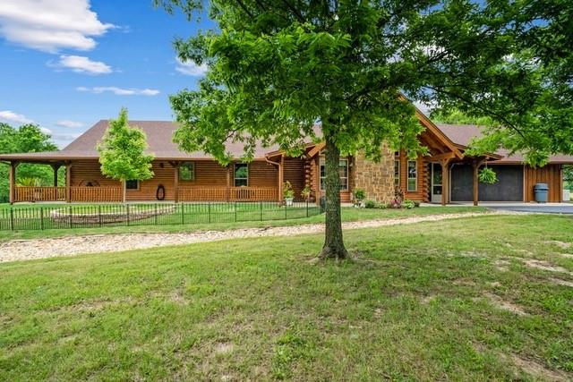 a view of a house with a backyard and a tree