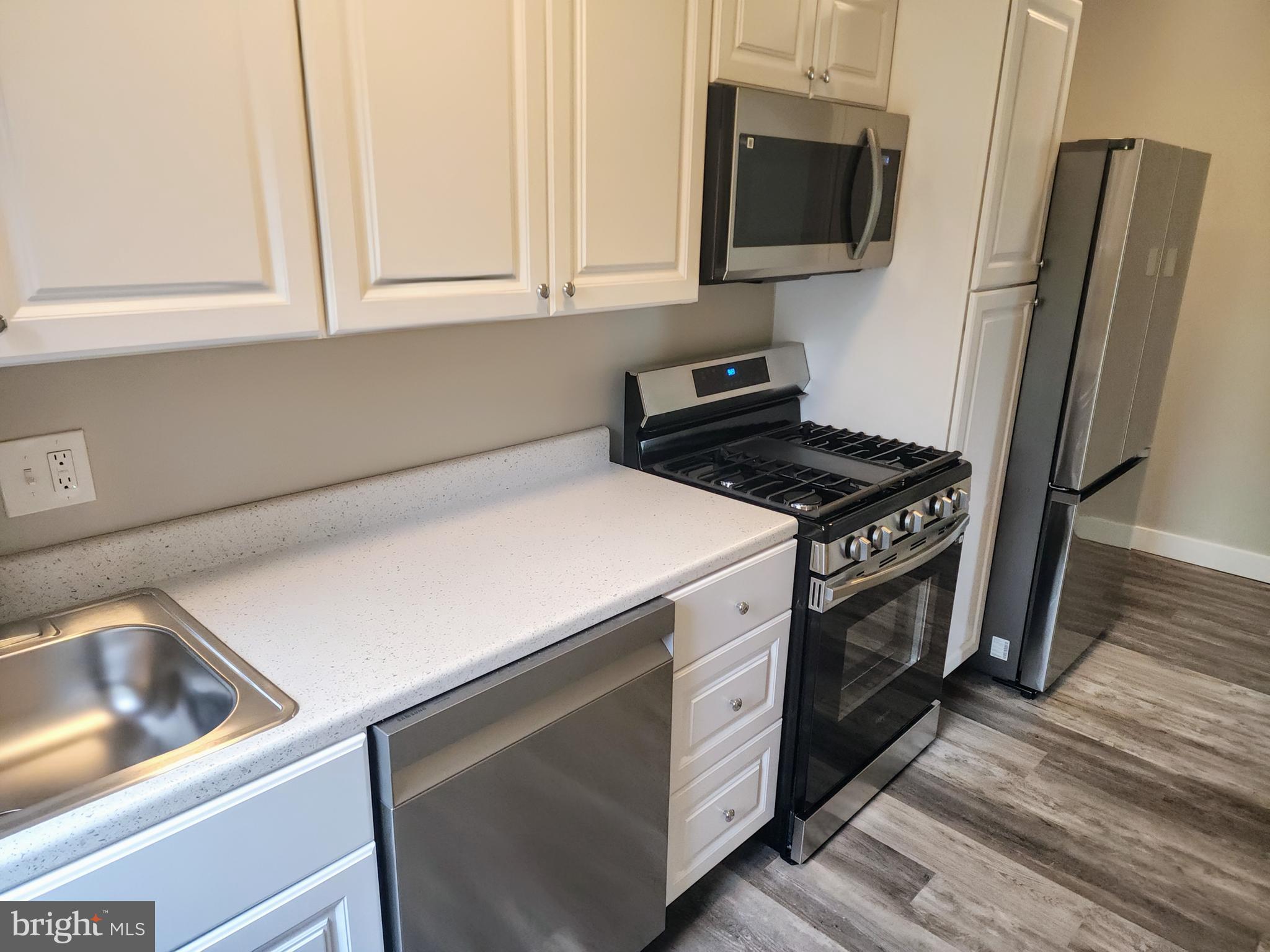 a kitchen with stainless steel appliances a stove microwave and refrigerator