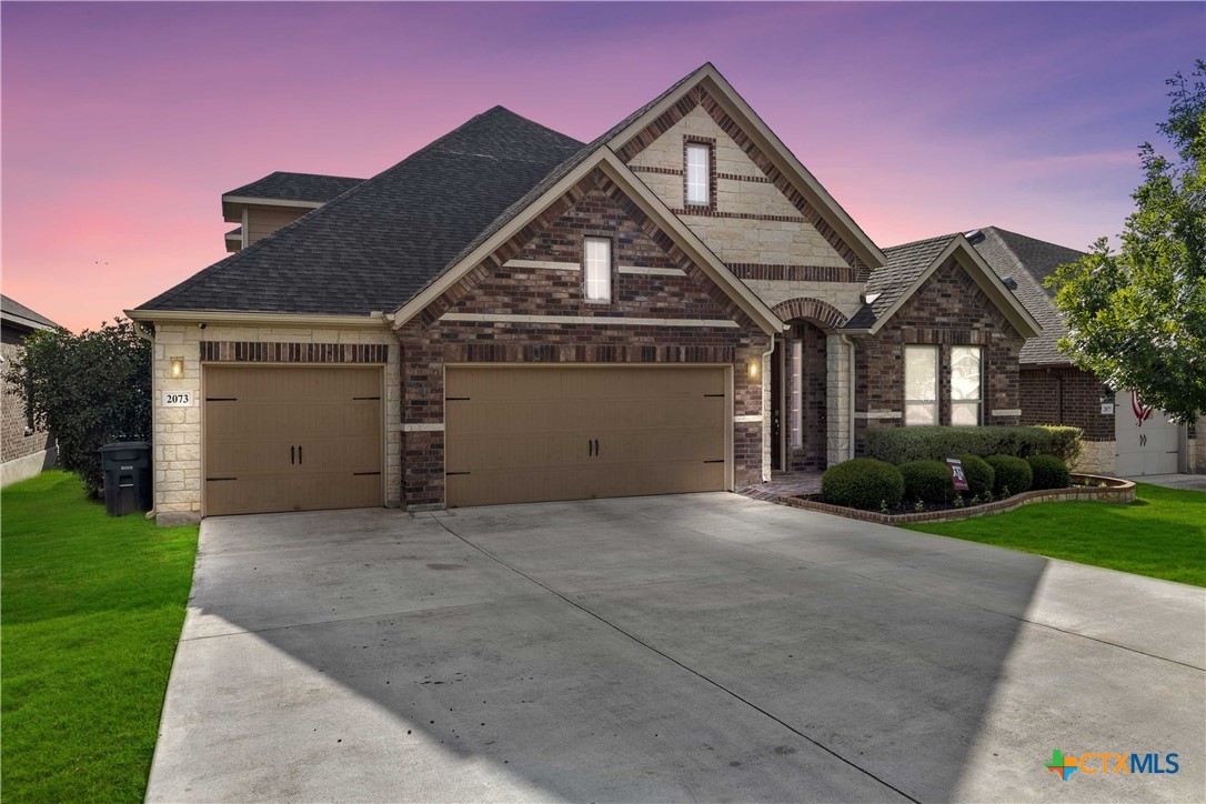 a front view of a house with a yard and garage