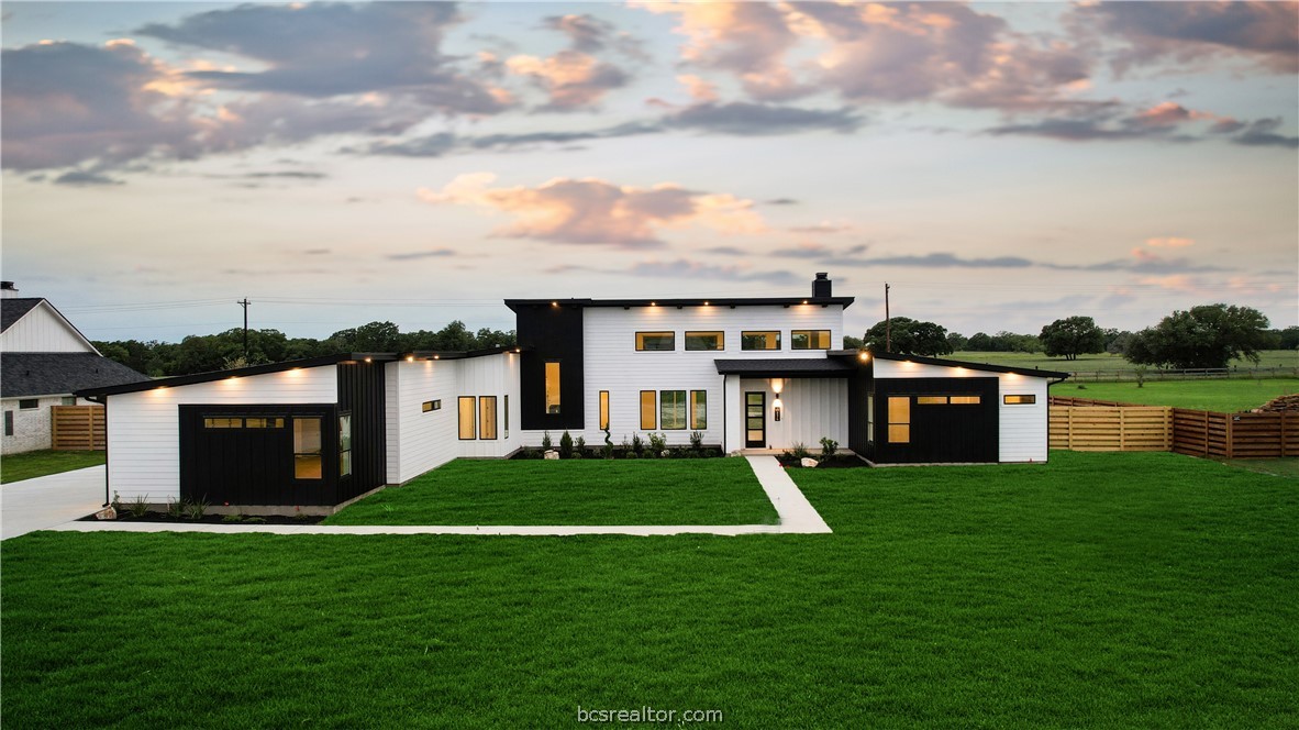 a front view of a house with yard and lake view