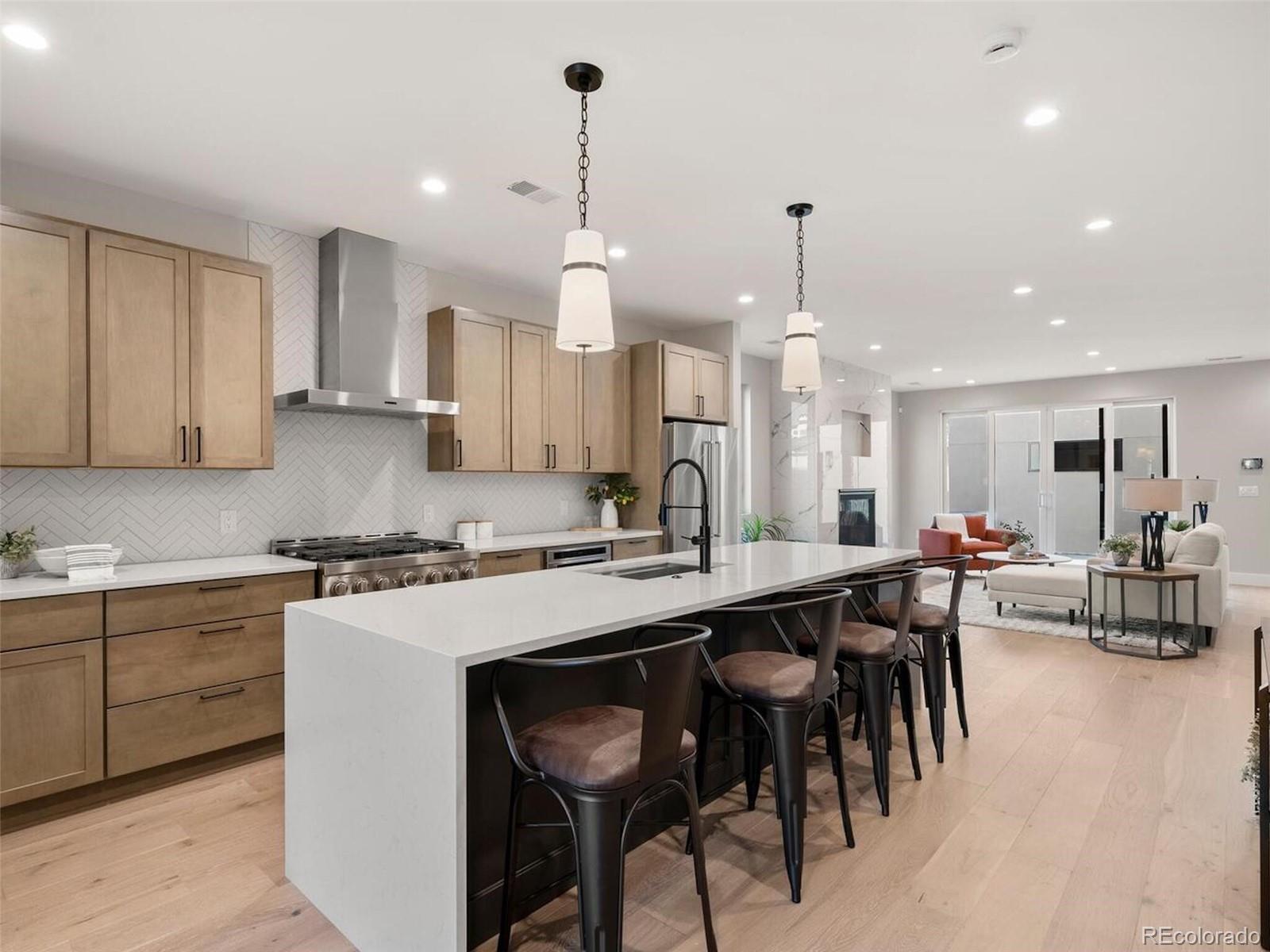 a kitchen with stainless steel appliances kitchen island granite countertop a table chairs sink and cabinets