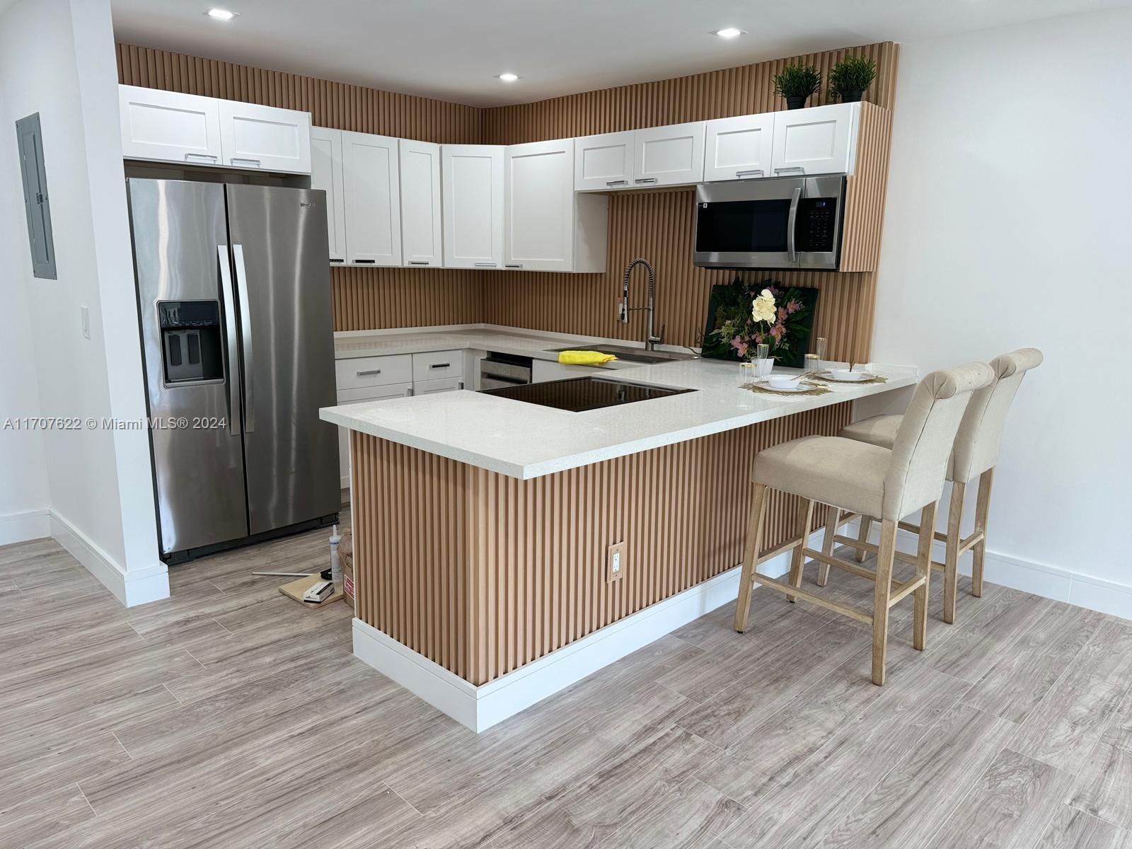 a kitchen with stainless steel appliances a stove a sink a refrigerator and a microwave