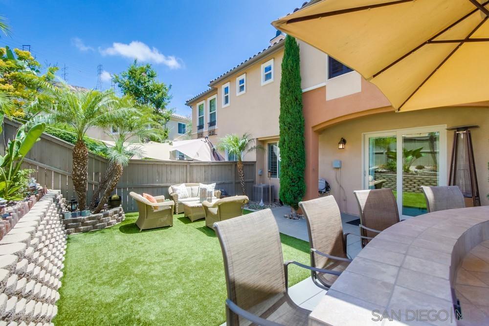 a view of a patio with couches table and chairs and potted plants