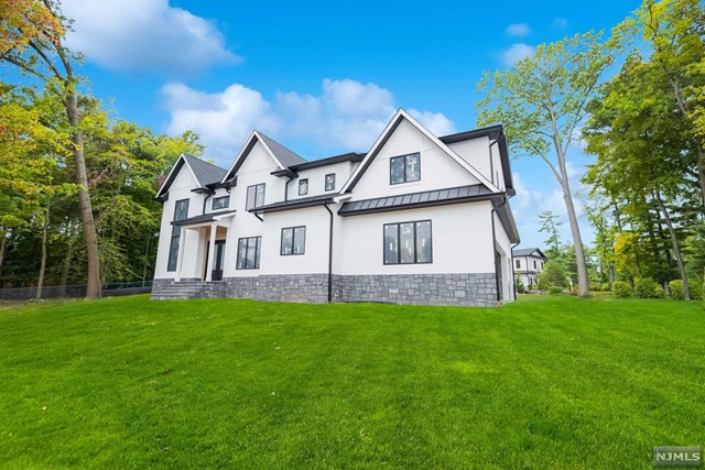 a front view of a house with a garden and trees