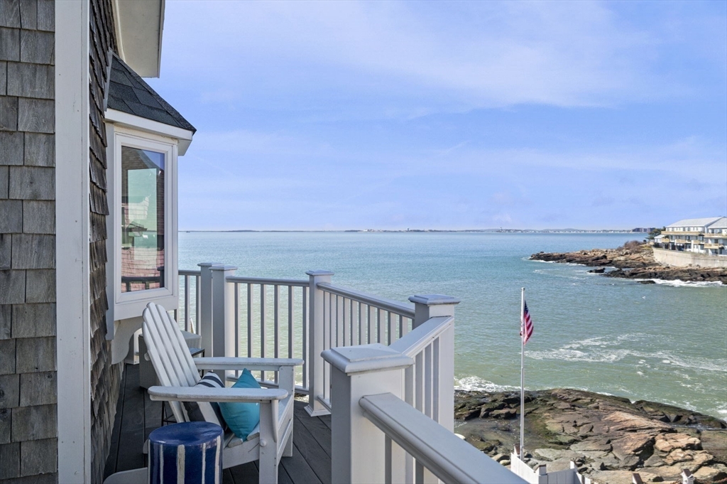 a view of a balcony with wooden chairs