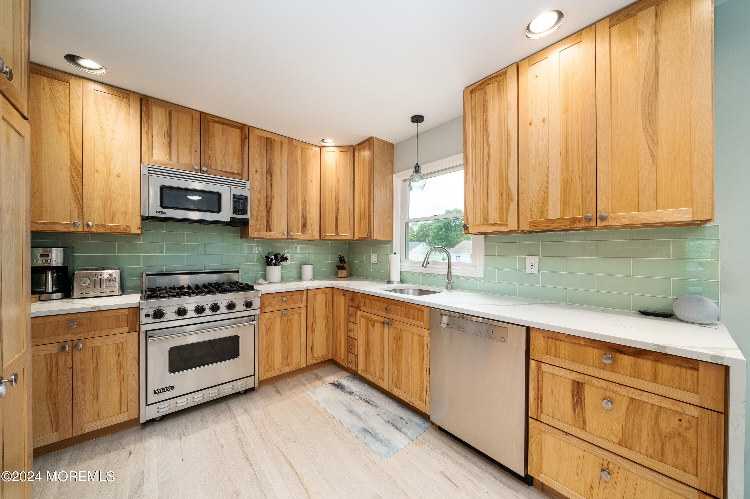 a kitchen with granite countertop wooden cabinets and a stove top oven