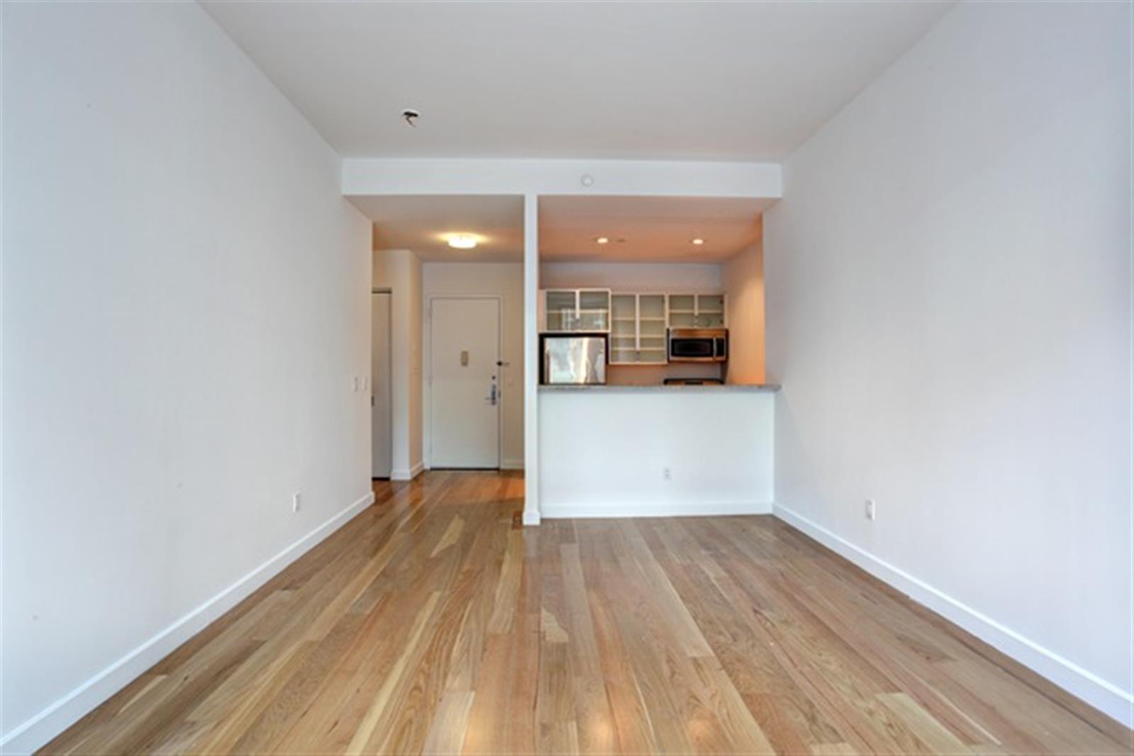 a view of a kitchen with wooden floor and a ceiling fan