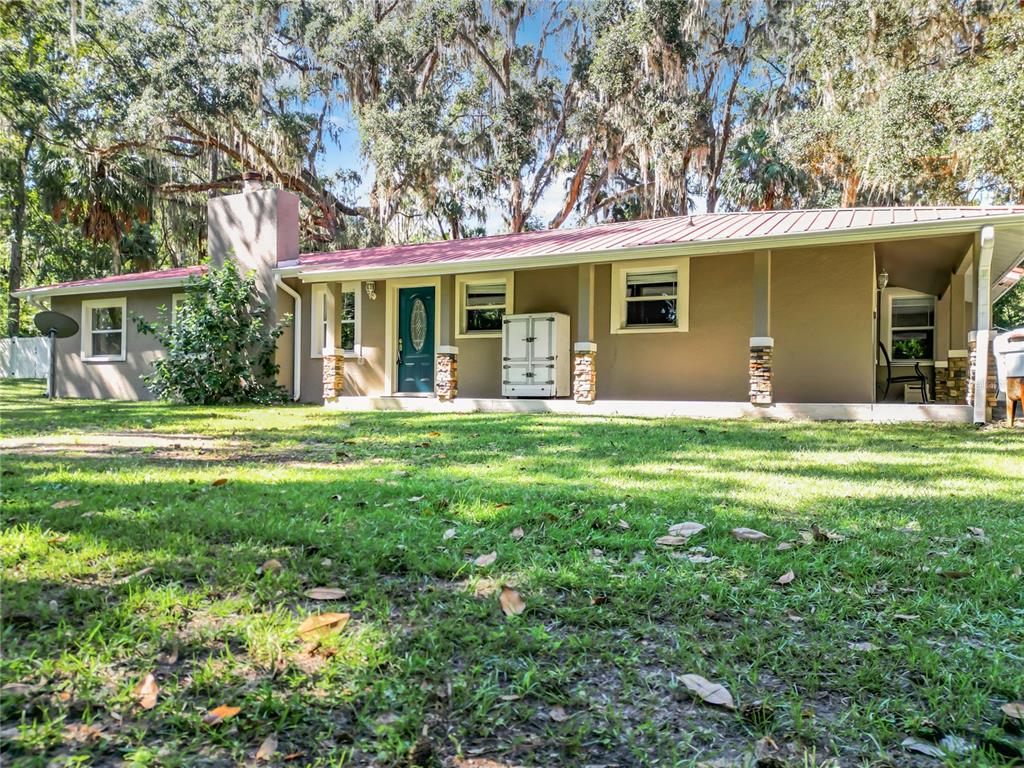 a front view of a house with yard and green space