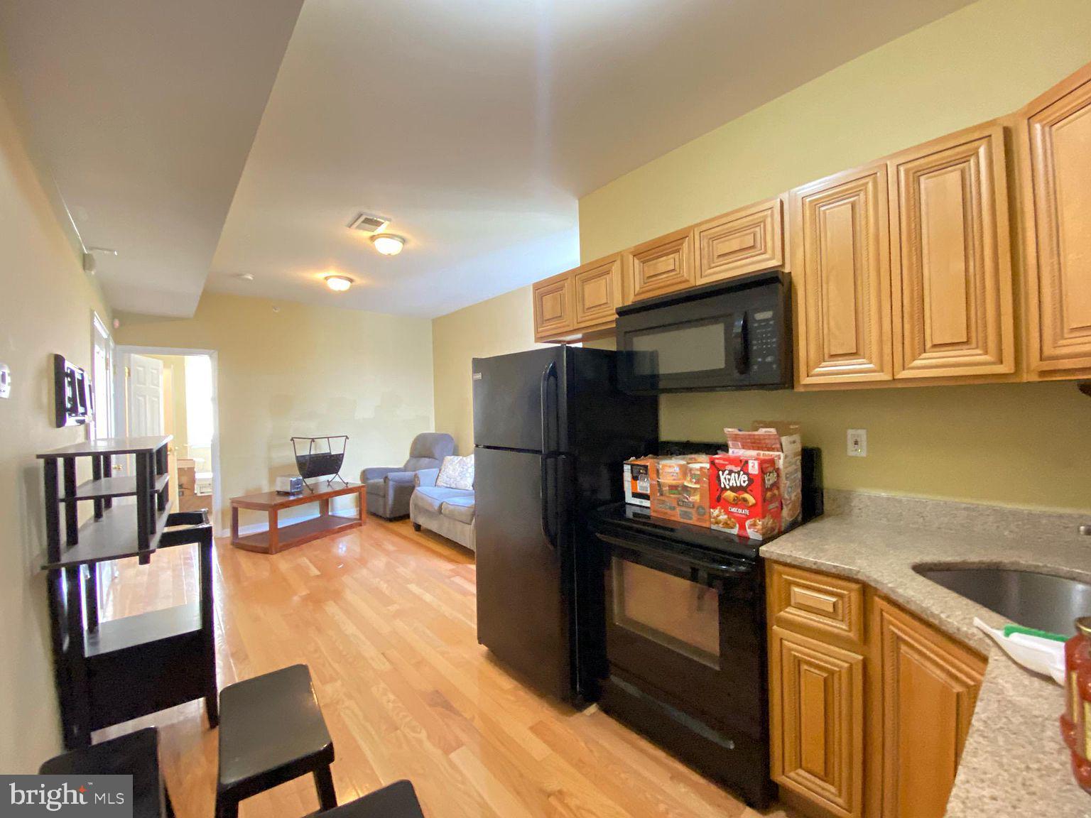 a kitchen with stainless steel appliances granite countertop a refrigerator stove top oven a sink and dishwasher