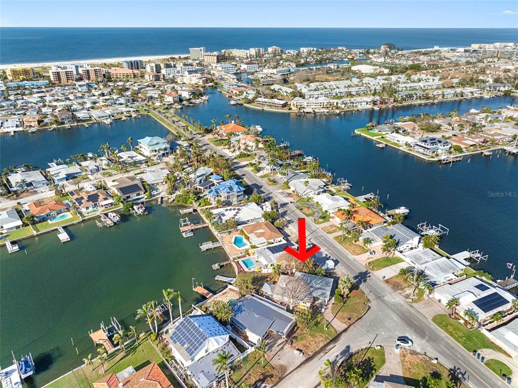 an aerial view of ocean and residential houses with outdoor space