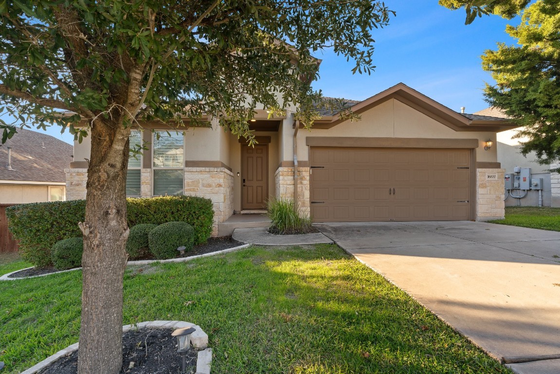 a front view of a house with a yard and garage