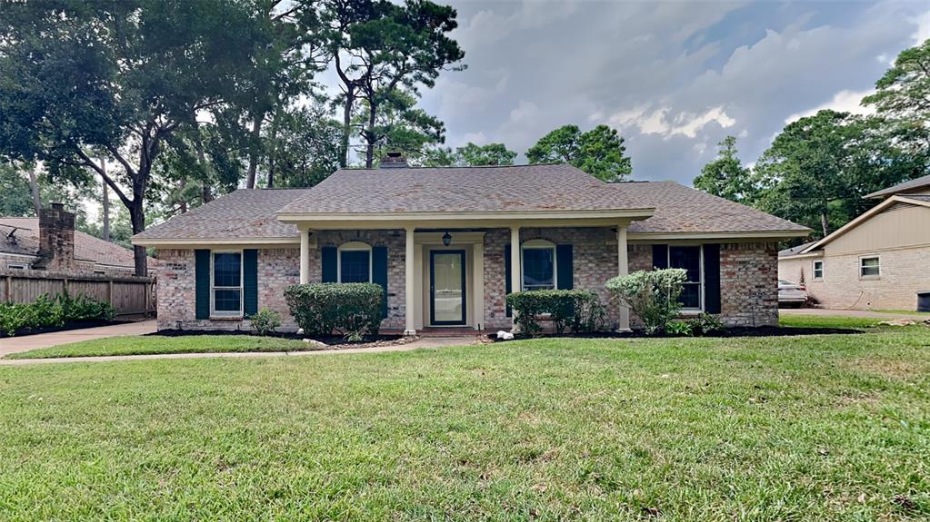 a front view of a house with a garden and trees