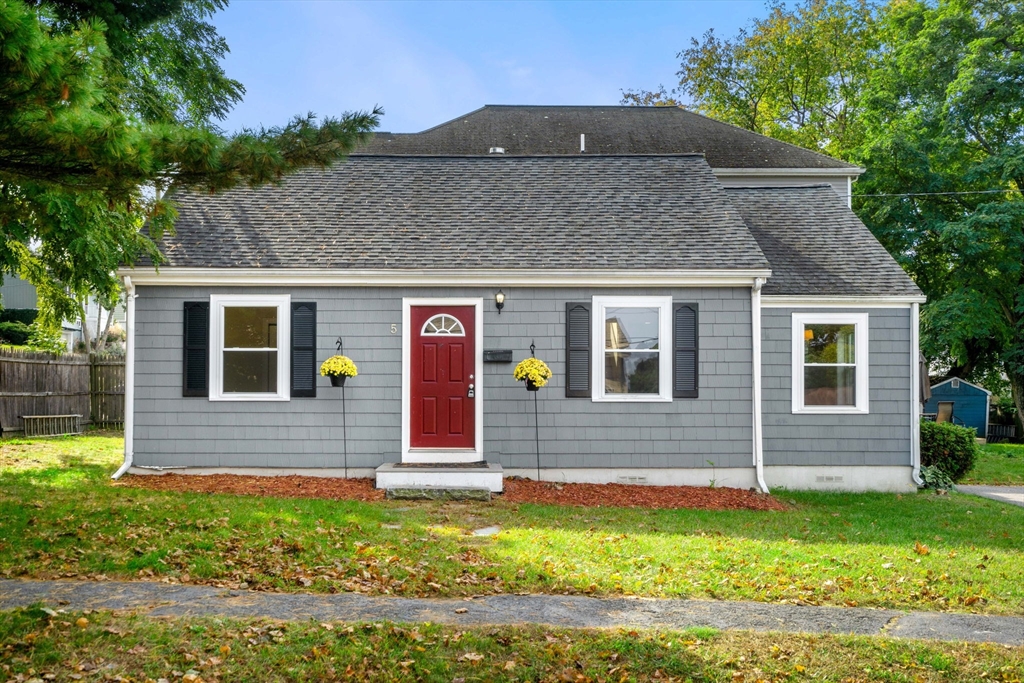 a brick house that has a small yard in front of it