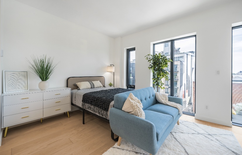 a bedroom with a large bed and windows