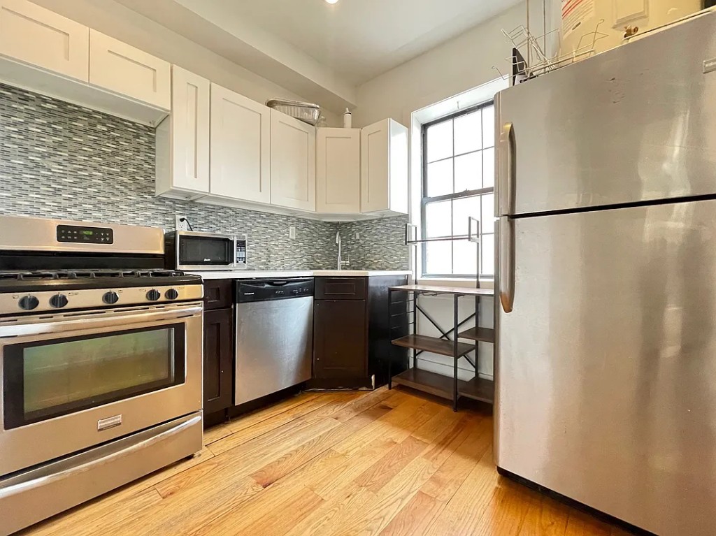 a kitchen with granite countertop a stove a sink and a microwave