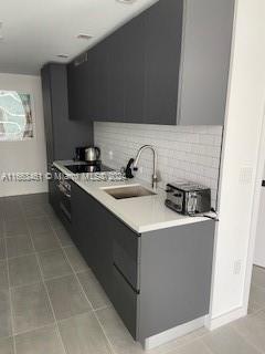 a kitchen with a sink a stove top oven and cabinetry