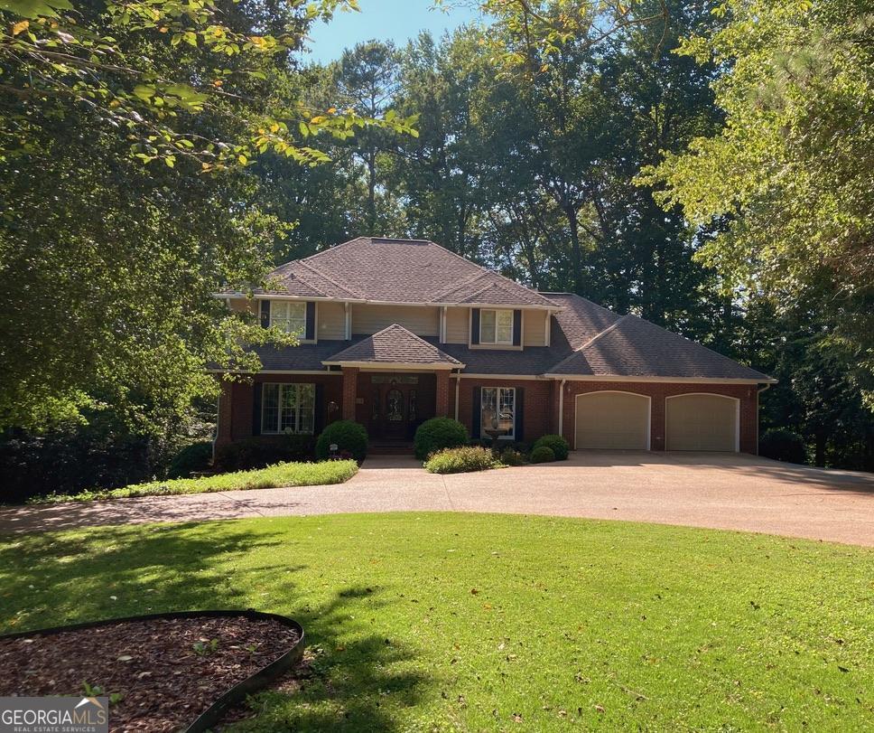 a front view of a house with yard and trees