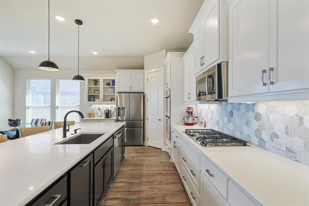 a kitchen with a sink stove top oven and refrigerator