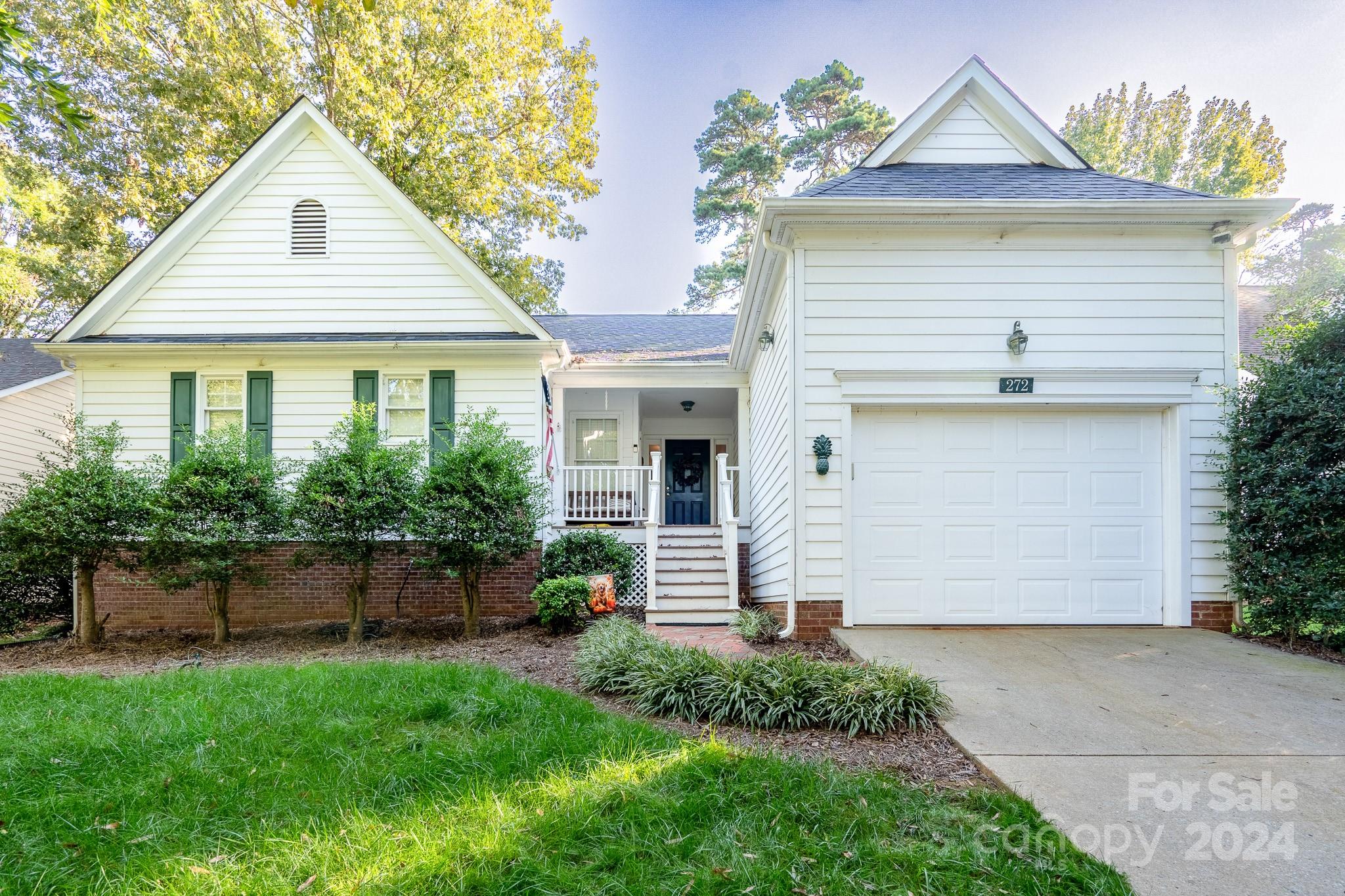 a front view of a house with a yard and potted plants