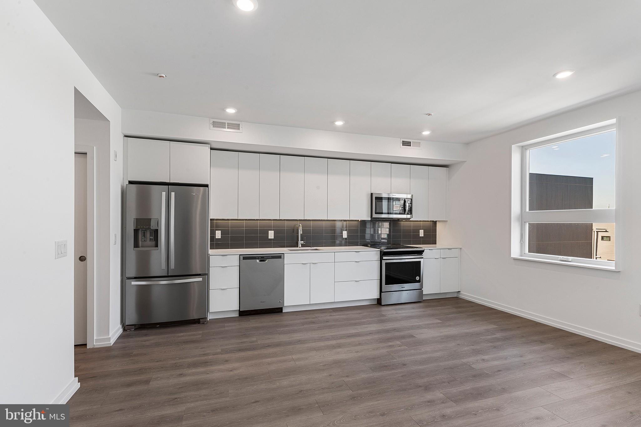 a kitchen with a refrigerator and a stove top oven