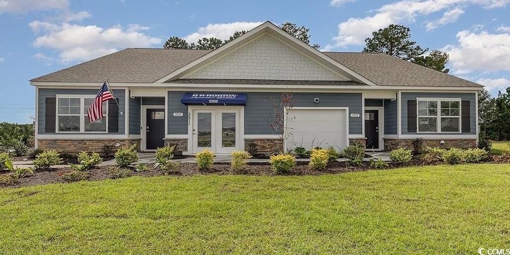 Craftsman-style house with a front yard and a gara