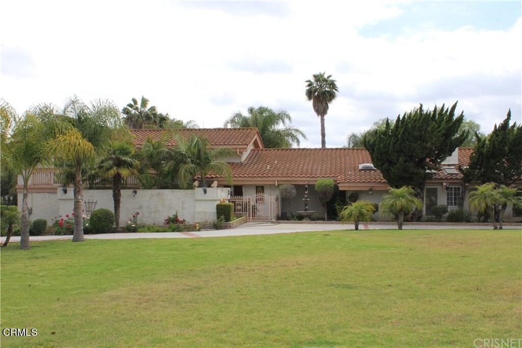 a view of house with yard and tree in front of it