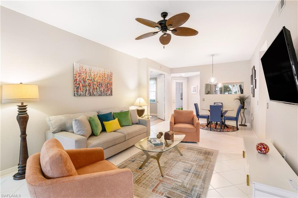 a living room with furniture kitchen view and a flat screen tv