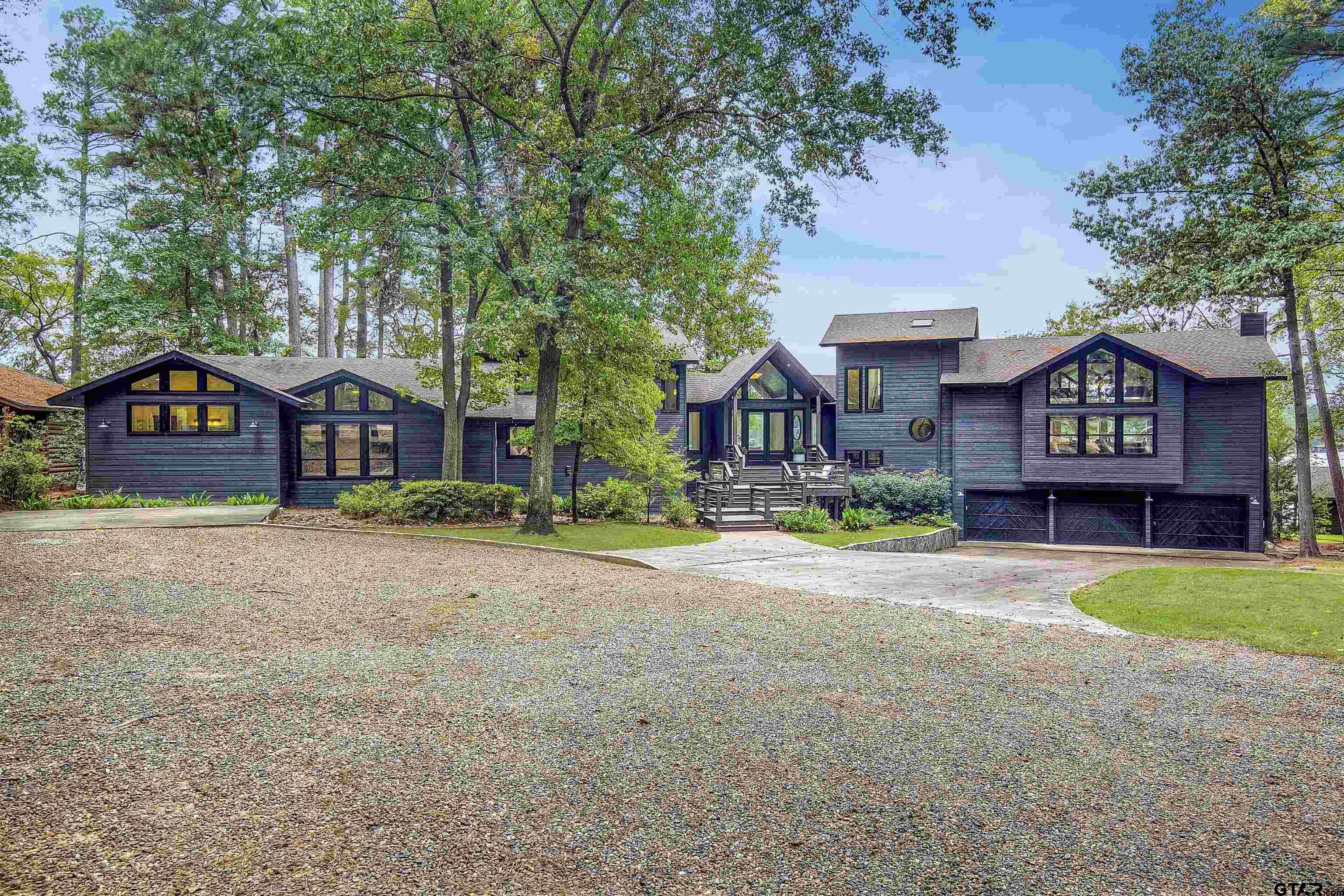 a front view of a house with yard and parking