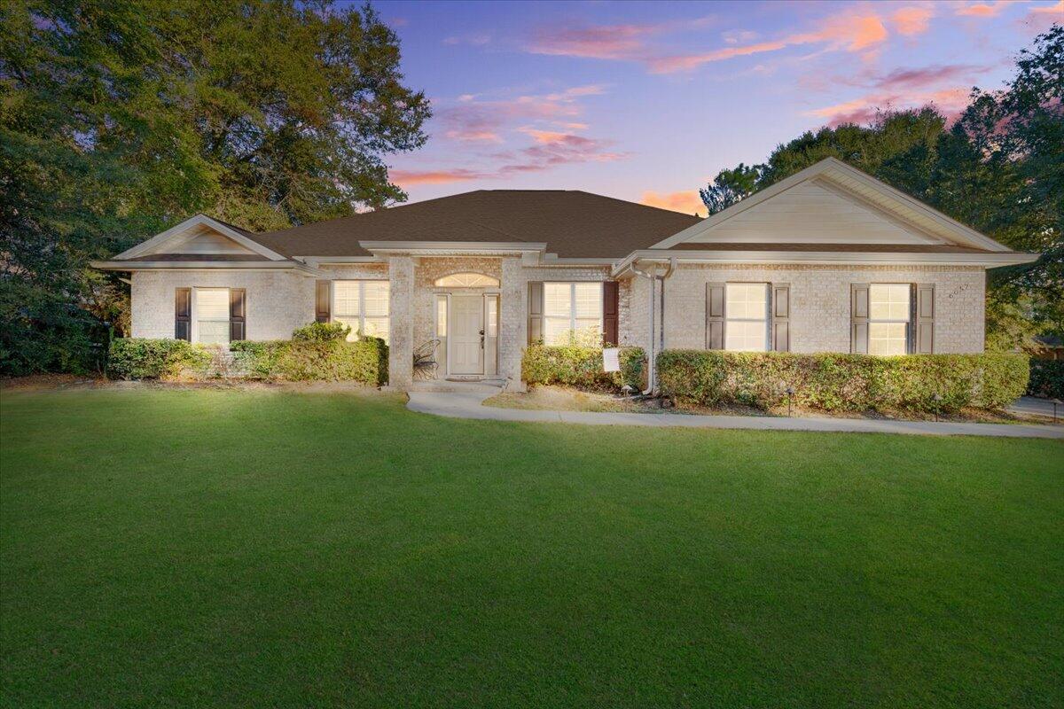 a front view of a house with a garden and yard