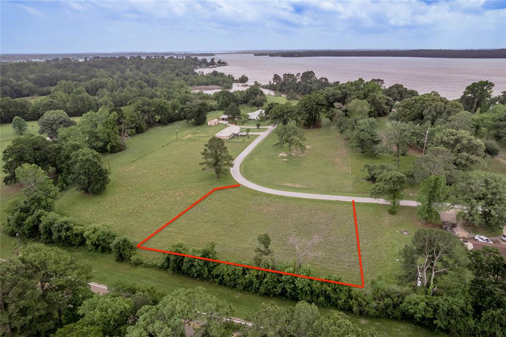 an aerial view of a houses with a yard and lake view