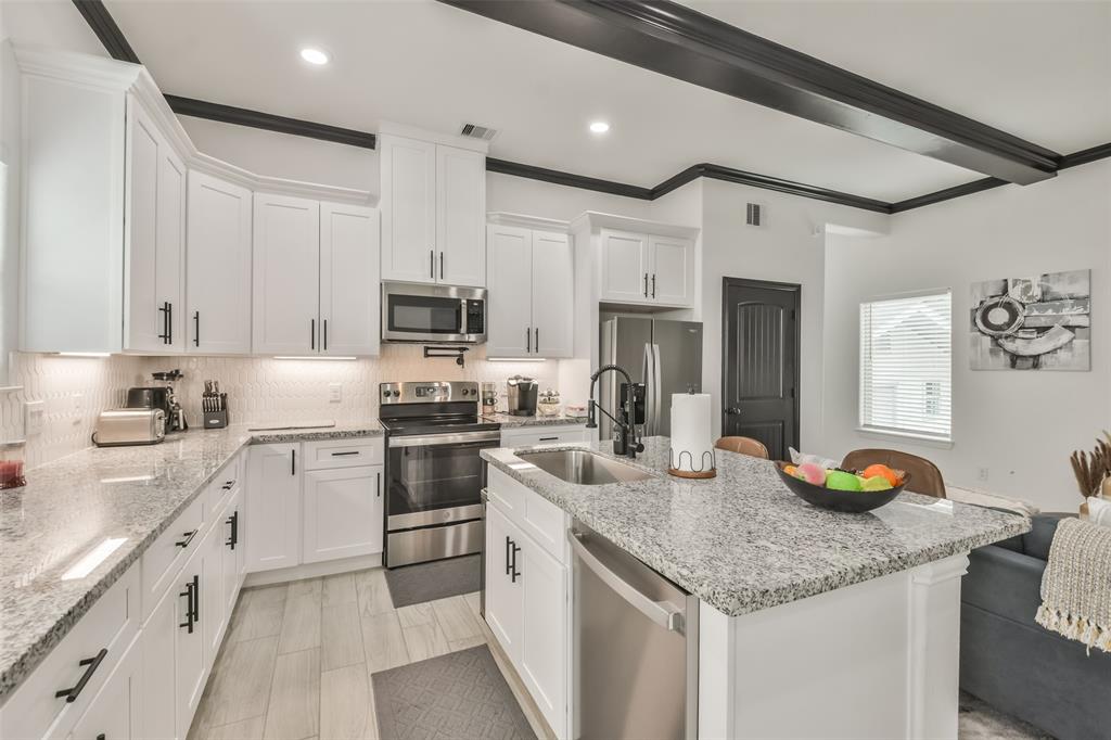 a kitchen with granite countertop stainless steel appliances and white cabinets