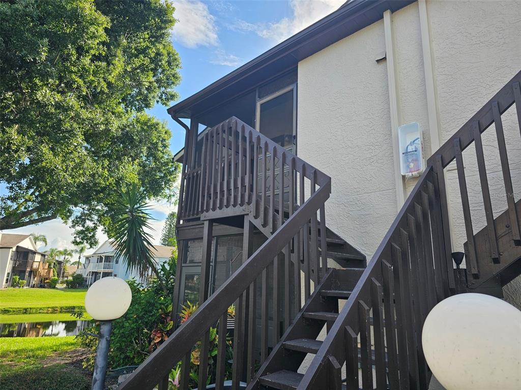 a view of a house with wooden stairs and a floor to ceiling window