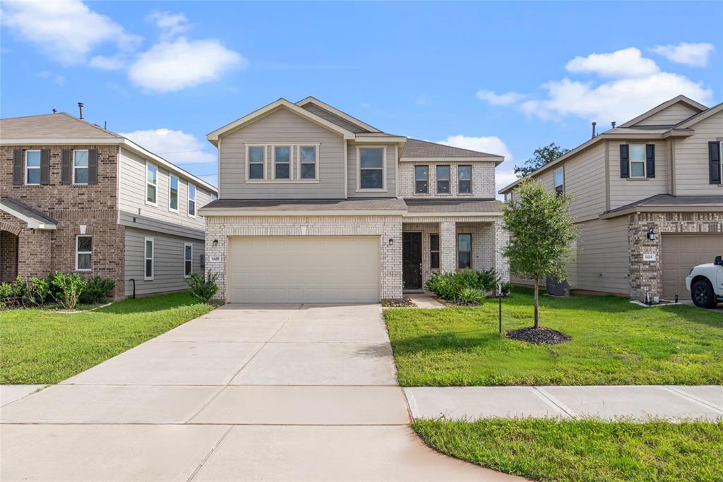 a front view of a house with a yard and garage