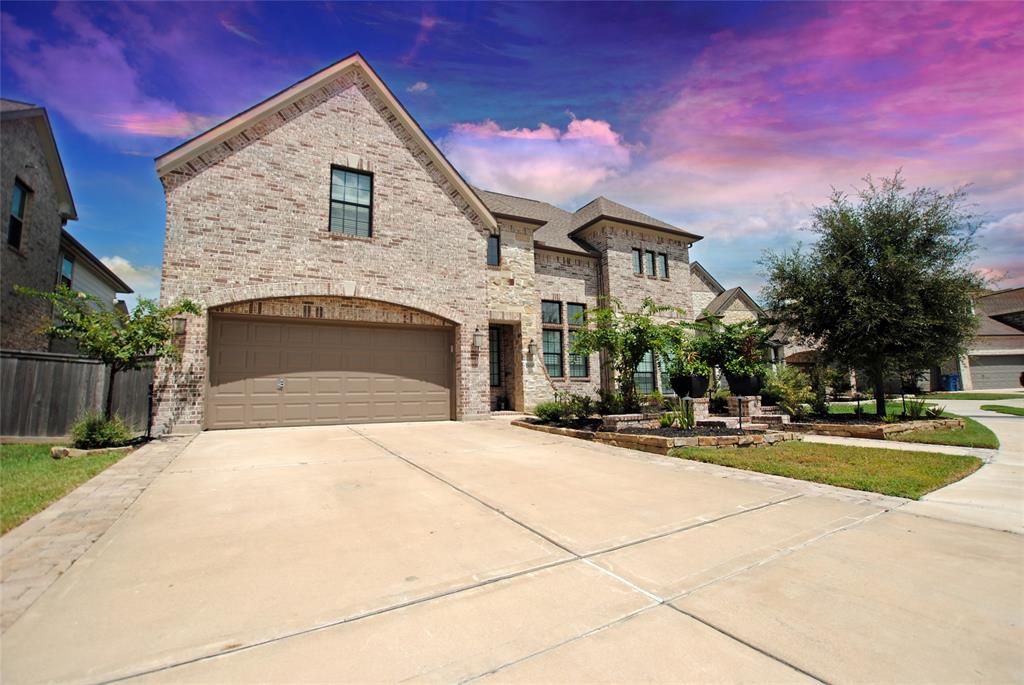 a front view of a house with yard and parking