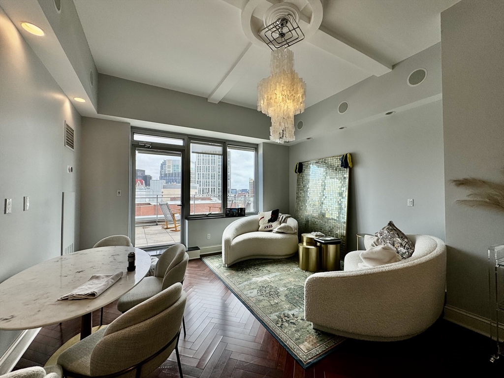 a living room with furniture chandelier and a large window