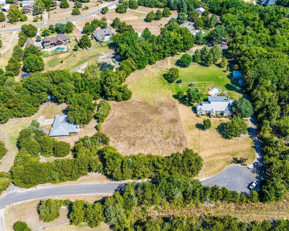 an aerial view of a house with a yard and lake view in back